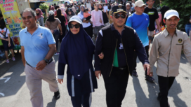 Pj Bupati Jombang, Teguh narutomo betrsama istri Ny. Irnie Victorynie Teguh Narutomo, didampingi tokoh muda Kopura bergerak dan berjalan bersama, dalam acara pembukaan CFD Brantas Utara, Ploso Jombang, Minggu 19 Januari 2025.  Foto: jombangkab.go.id