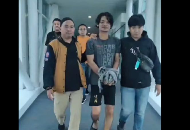 
					Polisi membawa Ainur Wahyudi, tersangka korupsi dana desa Rp 120,7 juta,  dua tahun menghilang dan bekerja sebagai sopir di perusahaan kayu di Balikpapan, kaltim. Tangkap layar video instagram@kabarterdepanmojokerto