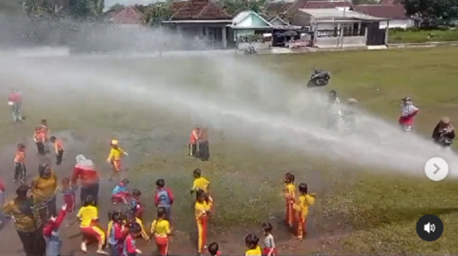 
					Tim Damkar Lumajang membuat kibin anak-anak 157 anak TK-PAUD riang gembira, bikin hujan buata dari pipa air mobil pemadam kebakaran di Lumajang, Selasa 18 Februari 2025. Tangkap layar video Instagram@damkar_kabupaten_lumajang