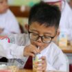 Salah seorang siswa menikmati menu sarapan pada pelaksanaan program MBG perdana di SD Taquma, Jemur Ngawinan No. 54 Surabaya, Senin (13/1/2025). Foto: Kominfo