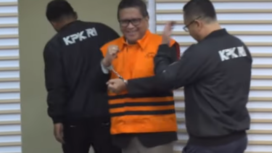 Di depan kamera wartawan Sekjen PDI-P, Hasto Kristiyanto mengangkt kedua tangannya yang diborgor sambil tersenyum, saat konferensi pers di gedung Merah-Putih KPK, Kamis 20 Februari 2025. Tangkap Layar Video Youtube@VivaNews