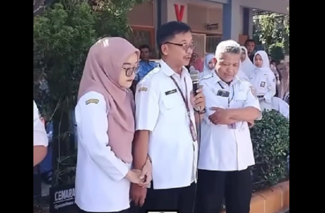 
					Inilah persoalannya, ibu guru ini merasa panik menghadapi demo siswanya sehingga berpegangan tangan di depan siswa saat aksi demo urusan SNBP dalam PPDS tahun 2025, pada tanggal 5 Februari 2025. Tangkap layar video Instagram@dramakuin.offical