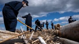 Petugas polisi ikut serta dalam operasi pencarian jenazah orang-orang yang hilang setelah bencana gempa bumi dan tsunami 11 Maret 2011 di Namie, prefektur Fukushima