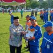 Bupati Jombang, H Warsubi saat membagikan paket sembako dan uang tunai kepada masyarakat di lapangan Pemkab Jombang, Kamis (20/32025) (Foto: KREDONEWS.COM/ Ipong D Cahyono)
