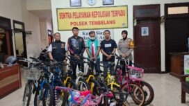 tersangka diapit petugas dengan sejumlah barang bukti