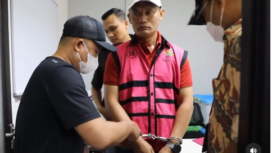 Petugas memasangkan baju oranye dan memborgol tangan ketua PN jakarta Selatan, Muhammad Arif Nuryanta, sebelium dibawa ke rutan untuk penahanan sementara, dalam kasus dugaan suap vonis bebas hukuman senilai Rp 60 miliar, di gedung Kejaksaan Agung, Sabtu malam, 12 April 2025. Tangkap layar video Instagram@kejaksaan_ri
