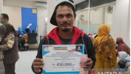 Seorang nelayan asal Kecamatan Muaragembong, Kabupaten Bekasi, Jawa Barat, menerima bantuan subsidi upah dari Pemkab Bekasi di Kantor Cabang Pembantu Bank Jabar Banten Sukatani. Foto: Antara