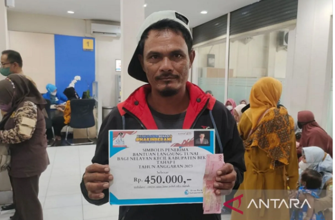 
					Seorang nelayan asal Kecamatan Muaragembong, Kabupaten Bekasi, Jawa Barat, menerima bantuan subsidi upah dari Pemkab Bekasi di Kantor Cabang Pembantu Bank Jabar Banten Sukatani. Foto: Antara