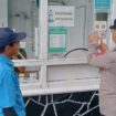 anggota Polres Batu saat menempel stiker 110 di salah satu tempat wisata di wilayah kota Batu