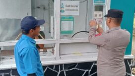 anggota Polres Batu saat menempel stiker 110 di salah satu tempat wisata di wilayah kota Batu