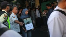 Istri mendiang dan Pelayat mengiringi jenazah diplomat Arya Daru Pangayunan yang dimakamkan di Karawang, Rabu (10/7). (Guntur Aga)