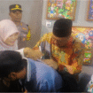 Bupati Jombang, Warsubi membubuhkan tanda tangan pada secarik kertas sebagai apresiasi terhadap permintaan siswi SDN II Kepanjen, peserta pameran lukis Membentang Ijo-Abang #10 di GOR Jombang, Rabu malam, 30 Juli 2025. Foto: kredonews.com/priyo suwarno