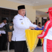 Bupati Jombang, Wrasubi menyerahkan bendara Merah - Putih, kepada petugas pengibar pada acara latihan perdana calon pengibar bendera pusaka (Capaska), di halaman Pendopo Kabupaten Jombang, Rabu, 30 Juli 2025. Foto: Diskominfo Jombang
