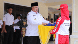 Bupati Jombang, Wrasubi menyerahkan bendara Merah - Putih, kepada petugas pengibar pada acara latihan perdana calon pengibar bendera pusaka (Capaska), di halaman Pendopo Kabupaten Jombang, Rabu, 30 Juli 2025. Foto: Diskominfo Jombang
