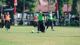 Kapolres Jombang saat berusaha menendang bola dengan mengenakan sarung