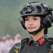 Seorang perwira polisi tugas khusus Kementerian Keamanan Publik mengenakan rompi tempur dan helm yang dilengkapi dengan komunikator radio.