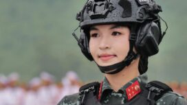Seorang perwira polisi tugas khusus Kementerian Keamanan Publik mengenakan rompi tempur dan helm yang dilengkapi dengan komunikator radio.