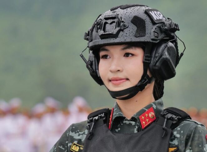 
					Seorang perwira polisi tugas khusus Kementerian Keamanan Publik mengenakan rompi tempur dan helm yang dilengkapi dengan komunikator radio.