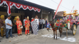 Kepala desa Plumbon Gambang, kecamatan Gudo, Jombang,  Nurwakit mengibarkan bendera start, memberangkatkan peserta pawai karnaval puncak acara peringatan  HUT-80 Proklamasi Indonesia, Sabtu 30 Agustus 2025. FotoL kredonews.com/ ipong dwicahyo
