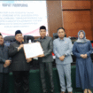 Bupati Jombang Warsubi memegani dokumen Persda Kerja Sama Daerah dan Smart City Jombang, yang disaahkan Senin, 27 Oktober 2025. Foto: Jombangkab.go.id