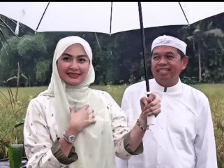 Berjalan di pematang sawah, saat hujan gerimis di Lembur Pakuan. Perempuan tamu dari Malaysia itu adalah anggota parlemen Di Raja Malaysia, bernama Young Syefura Othman, bertamu ke rumah kediaman Dedy Mulyadi, Lembur Pakuwan, kamis 11 Desember 2025. Foto: Instagram@dedimulyadi71