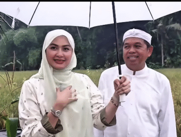 Berjalan di pematang sawah, saat hujan gerimis di Lembur Pakuan. Perempuan tamu dari Malaysia itu adalah anggota parlemen Di Raja Malaysia, bernama Young Syefura Othman, bertamu ke rumah kediaman Dedy Mulyadi, Lembur Pakuwan, kamis 11 Desember 2025. Foto: Instagram@dedimulyadi71