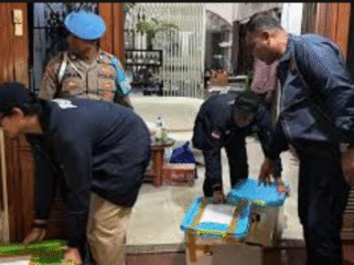 Petugas Bareskrim Polri membawa box plastik diduga wadah emas sitaan yang ditemukan di rumah TW, pemilik toko emas Semar, di Nganjuk. Foto: keuanganews.co