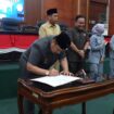 Bupati Jombang H Warsubi menandatangangi naskah rekomendasi dari DPRD tentang LPKJ APBD 2025, dalam sidang paripurna di gedung DPRD Jombang, Senin 20 April 2026. Foto: Instagram@dprd_jombang