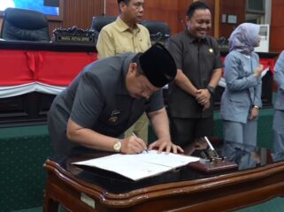 Bupati Jombang H Warsubi menandatangangi naskah rekomendasi dari DPRD tentang LPKJ APBD 2025, dalam sidang paripurna di gedung DPRD Jombang, Senin 20 April 2026. Foto: Instagram@dprd_jombang