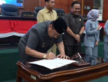 Bupati Jombang H Warsubi menandatangangi naskah rekomendasi dari DPRD tentang LPKJ APBD 2025, dalam sidang paripurna di gedung DPRD Jombang, Senin 20 April 2026. Foto: Instagram@dprd_jombang