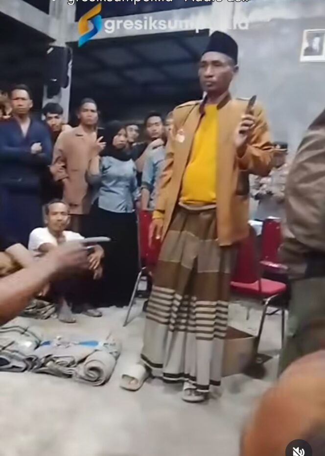 
					Warga menggiring dua oknum polisi di balai desa Petubg, Panceng, Gresik, Minggu malam 16 Agustus 2026. Foto: Instagram@gresiksumpek.id