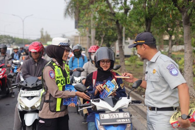 
					Foto:Istimewa
Petugas memberikan coklat gratis kepada pengguna jalan yang dinilai tertib.